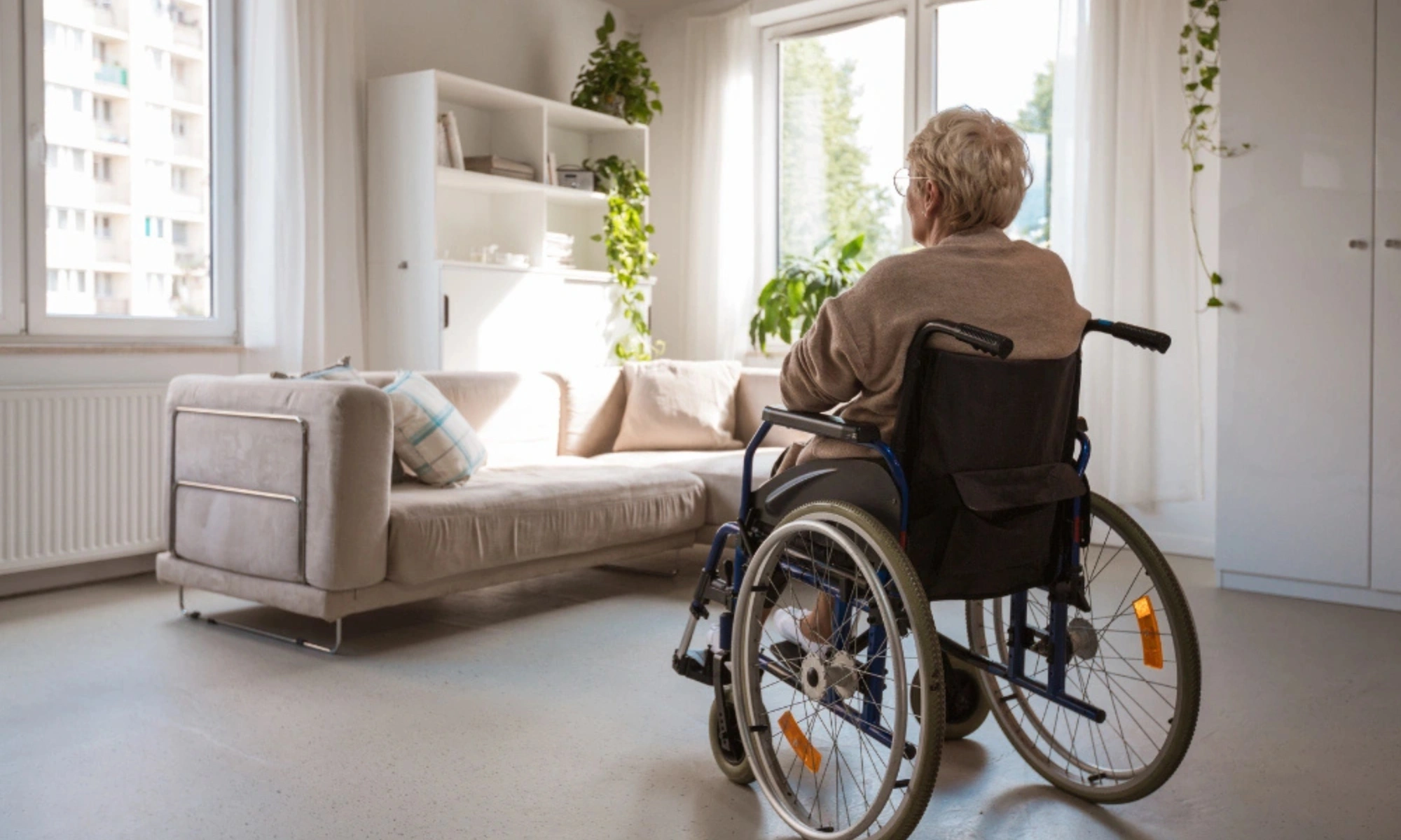 Lonely senior woman sitting in wheelchair in her house